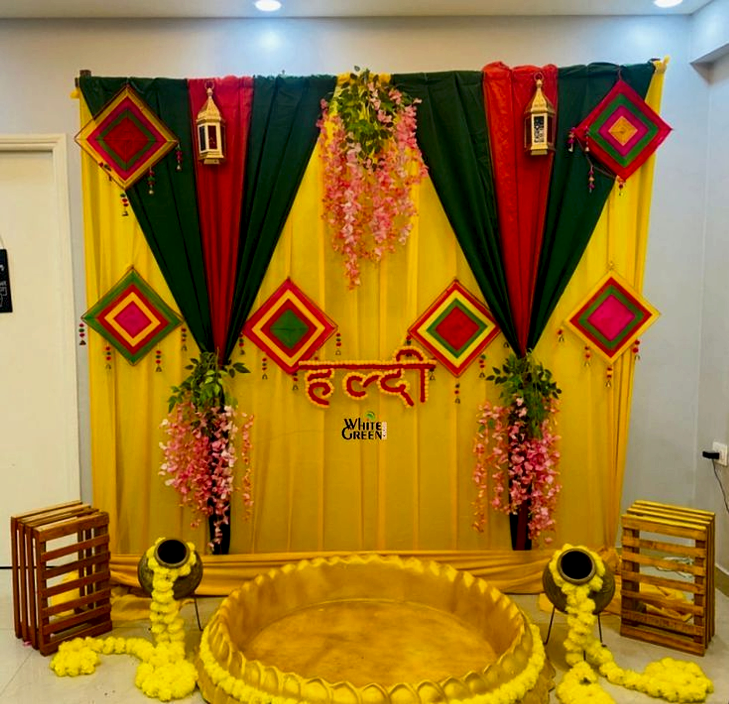 Traditional Haldi Ceremony Decoration With Yellow Green Backdrop And Floral Elements